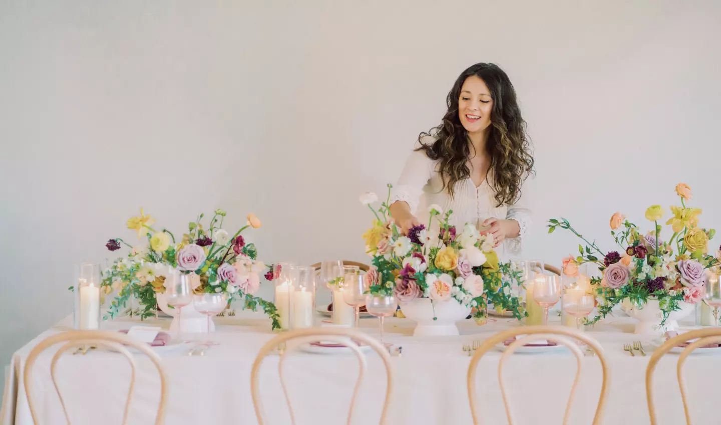 Busy Bee Bouqets owner Madi Blasingame setting up a floral arrangement on a table