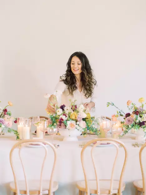 Busy Bee Bouqets owner Madi Blasingame completing a floral arrangement for a wedding table