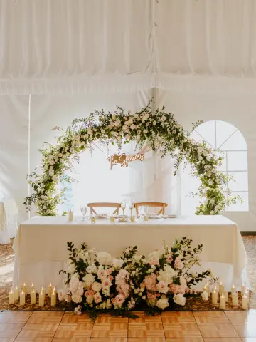 newlyweds table with a beautiful flower arch by Busy Bee Bouquets